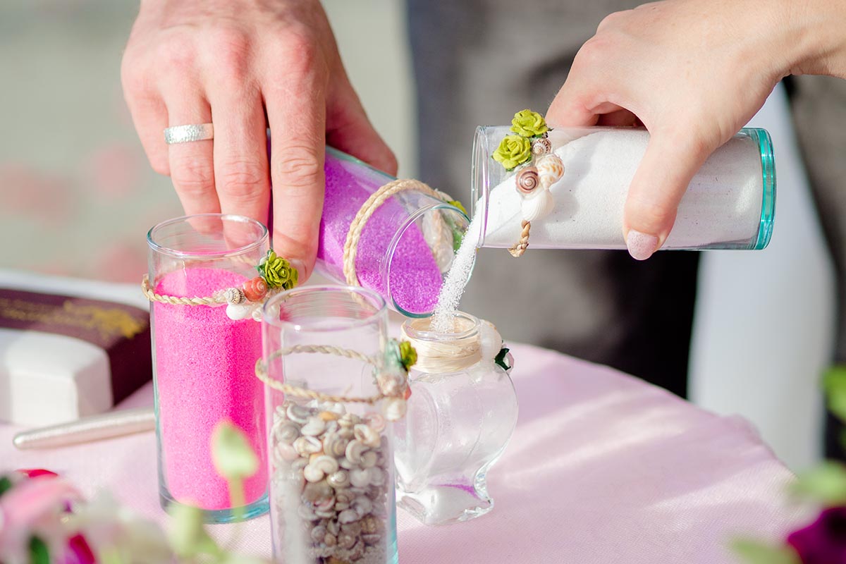 Sandzeremonie Hochzeit - Sande werden vom Brautpaar in das Glas gegossen